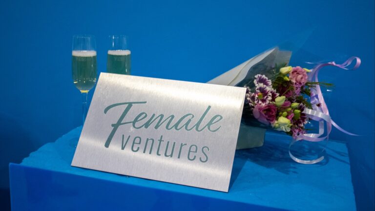 Female ventures logo on a blue table